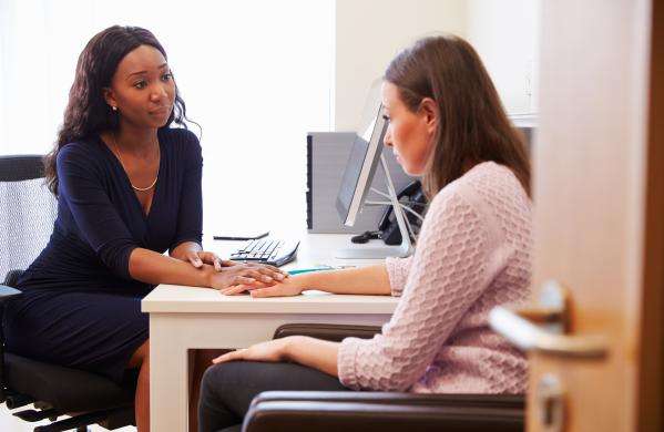 Lady comforts lady with mental health issues