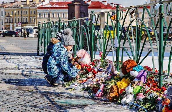 Child lays memorial flowers