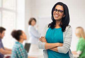 Smiling woman with people in office background.