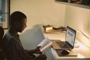 Man sits at computer studying - emmanuel-ikwuegbu