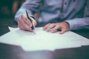 Man working at desk with pen and paper