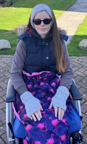 A young woman sits in a wheelchair