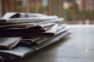 A stack of newspapers on an office table